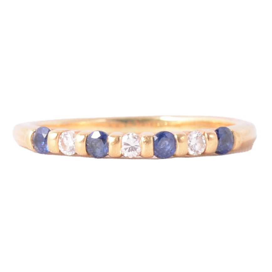 Lot 18 - A sapphire and diamond half eternity ring.