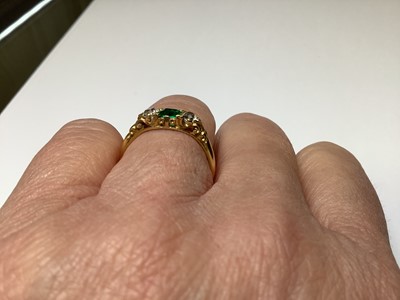 Lot 22 - An emerald and diamond three stone ring.
