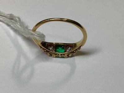 Lot 22 - An emerald and diamond three stone ring.