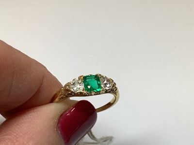 Lot 22 - An emerald and diamond three stone ring.