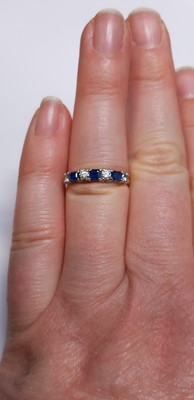 Lot 15 - A sapphire and diamond half eternity ring.