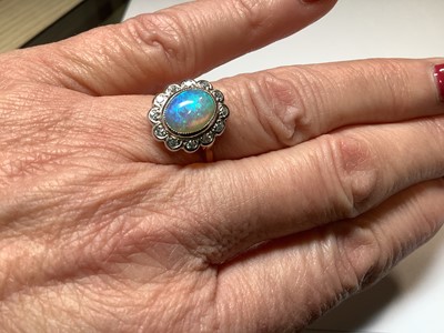Lot 50 - An opal and diamond oval cluster ring.