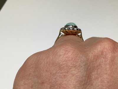 Lot 50 - An opal and diamond oval cluster ring.