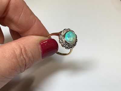 Lot 50 - An opal and diamond oval cluster ring.