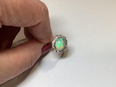 Lot 50 - An opal and diamond oval cluster ring.