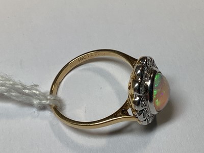 Lot 50 - An opal and diamond oval cluster ring.