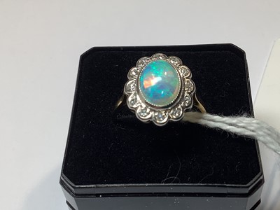 Lot 50 - An opal and diamond oval cluster ring.