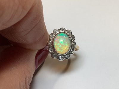 Lot 50 - An opal and diamond oval cluster ring.