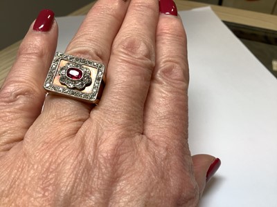 Lot 33 - A ruby and diamond square cluster ring on a heavy band.