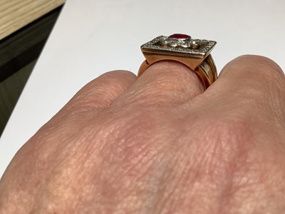 Lot 33 - A ruby and diamond square cluster ring on a heavy band.