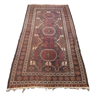 Lot 552 - Belouchi rug, with three medallions, on a fawn...