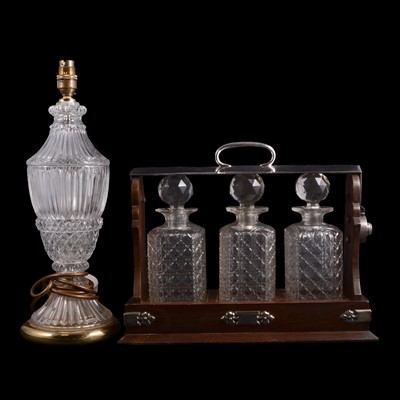 Lot 124 - A three bottle tantalus and a glass table lamp.
