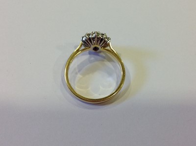 Lot 26 - A ruby and diamond oval cluster ring.