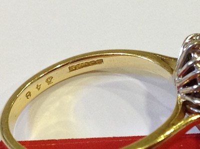 Lot 26 - A ruby and diamond oval cluster ring.