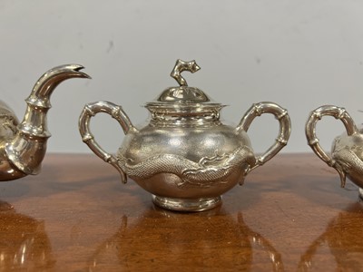 Lot 45 - Chinese silver three piece teaset with sugar tongs and a rosewood tray