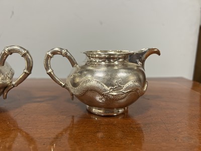 Lot 45 - Chinese silver three piece teaset with sugar tongs and a rosewood tray