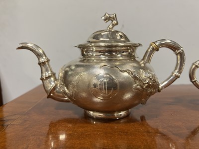 Lot 45 - Chinese silver three piece teaset with sugar tongs and a rosewood tray